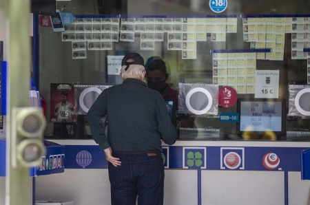 Un cliente compra lotería en una administración (MARÍA JOSÉ LÓPEZ / EUROPA PRESS)