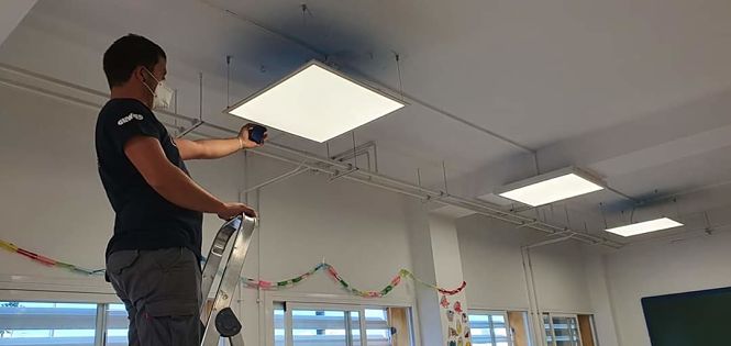 Un técnico municipal trabajan en la instalación de las luces LED en el colegio Francisco Ayala (AYTO. CULLAR VEGA)