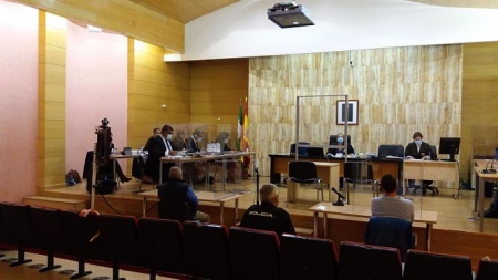Juicio al supuesto autor del asesinato y enterramiento de su mujer en Guadix, de espaldas, el primero a la izquierda del policía en la imagen (EUROPA PRESS)