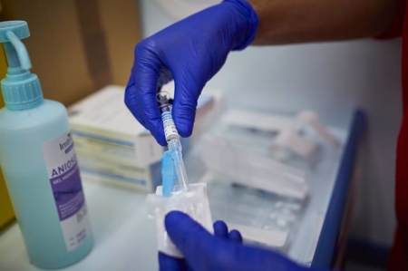Un sanitario de Cruz Roja se prepara para administrar la vacuna contra la gripe en un punto de vacunación (JESÚS HELLÍN - EUROPA PRESS)