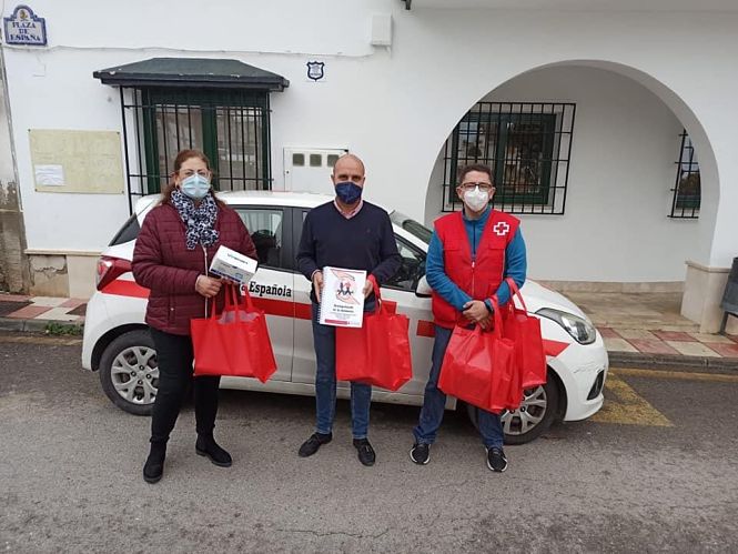 la concejala Aurora Sousa y el alcalde de Otura, junto a uno de los voluntarios de Cruz Roja, reparten un detalle a los mayores del municipio que han participado en el programa `Acompañando en la distancia` (AYTO. OTURA) 