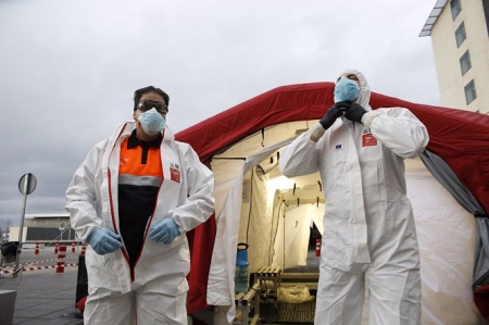Trabajadores de proteccion civil se desinfectan contra el coronavirus en una carpa instalada en el hospital del PTS (ÁLEX CÁMARA / EUROPA PRESS) 