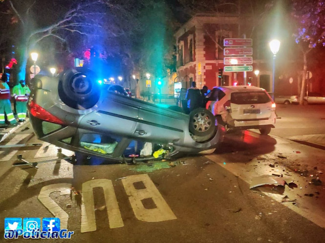 El turismo volcó tras chocar con el taxi, parado en un semáforo en rojo en la avenida del Hospicio POLICIA LOCAL GRANADA)