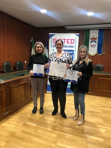 la concejala de Turismo, Encarna Domínguez, y la gestora del destino Monachil-Sierra Nevada, Irene Arquelladas del Paso, entregan su distintivo SICTED a las empresas que lo han renovado (AYTO. MONACHIL)