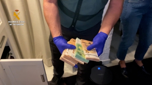 Un agente con el dinero incautado en uno de los registros (GUARDIA CIVIL)