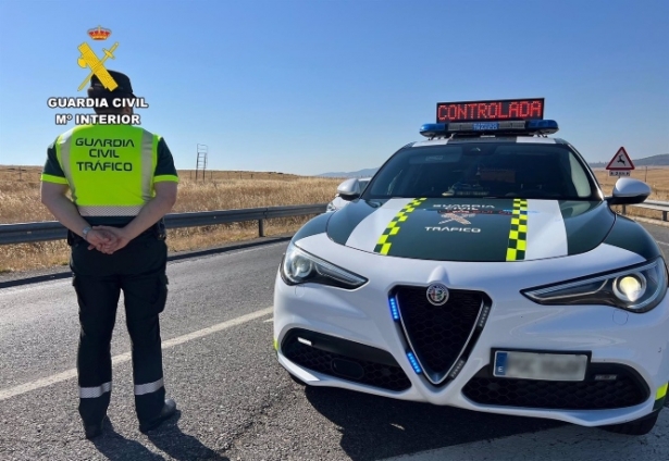 Un agente de la Guardia Civil de Tráfico junto a su vehículo en una carretera (GUARDIA CIVIL) Un agente de la Guardia Civil de Tráfico junto a su vehículo en una carretera (GUARDIA CIVIL)