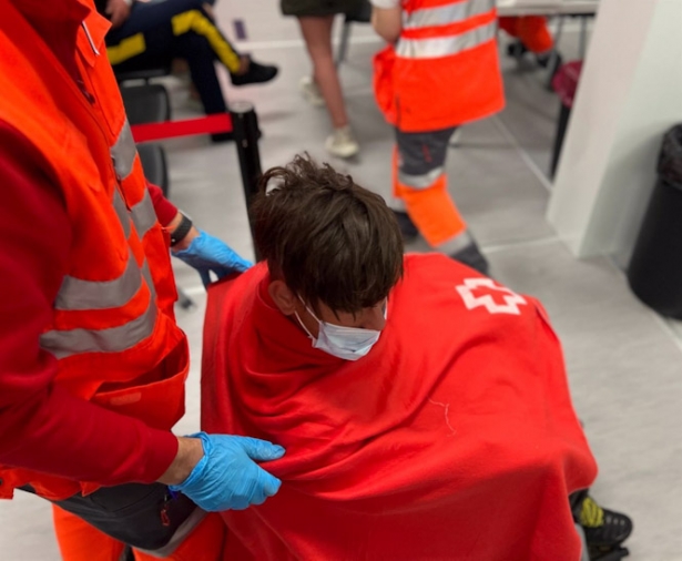 Un voluntario de Cruz Roja junto a un inmigrante llegado en patera (CRUZ ROJA)