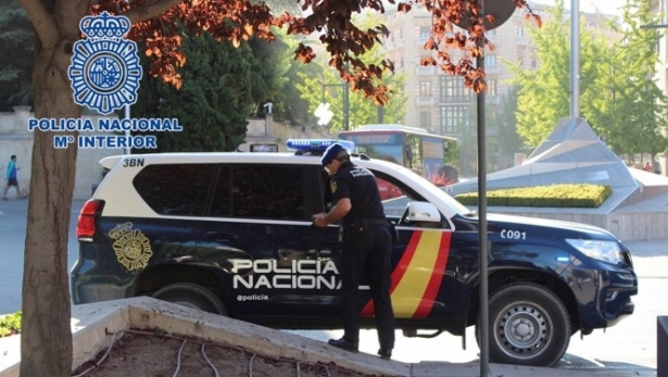 Agente de la Policía Nacional junto a un vehículo policial. Archivo (POLICÍA NACIONAL)