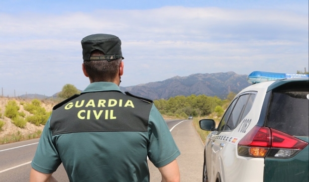 Un agente de la Guardia Civil junto a un vehículo en una carretera (GUARDIA CIVIL) 