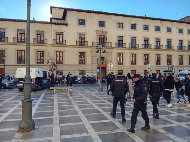 Familiares de la víctima y agentes en Plaza Nueva, a la salida del furgón policial donde iba el acusado de matar a un hombre en Churriana de la Vega (EUROPA PRESS)