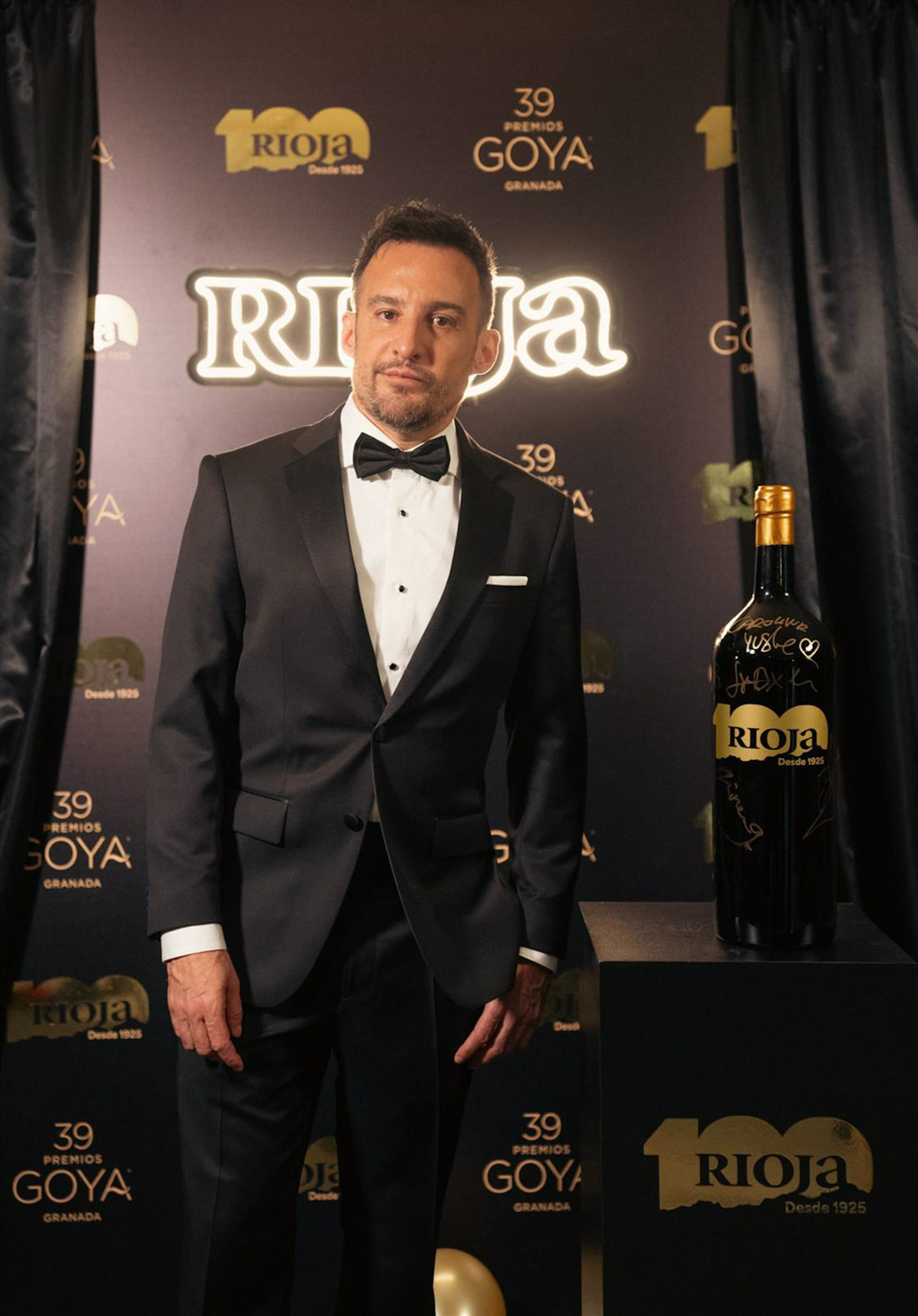 El director de cine Alejandro Aménabar posa junto a una de las dos botellas especiales Rioja Edición Centenario en la gala de Los Goya (DOCA RIOJA)
