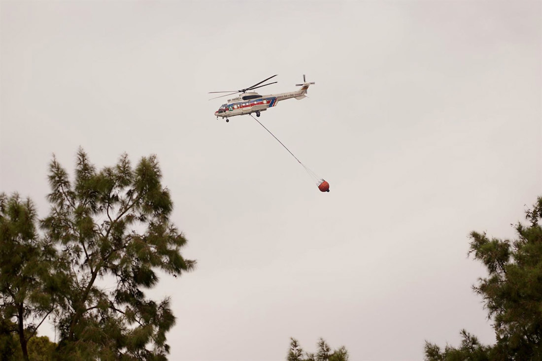 Un helicóptero del Infoca arroja agua sobre el incendio, a 7 de octubre de 2024, en Málaga, Andalucía (ÁLEX ZEA - EUROPA PRESS)