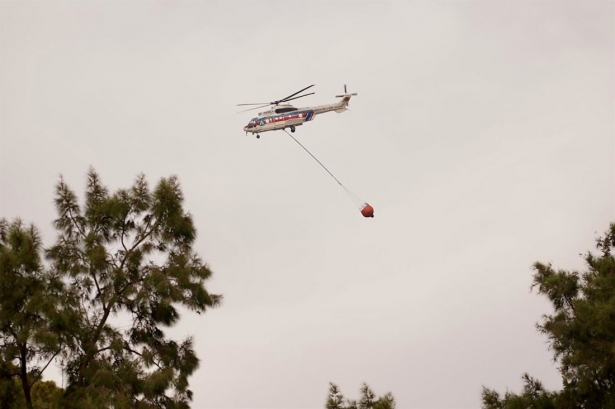 Un helicóptero del Infoca arroja agua sobre el incendio, a 7 de octubre de 2024, en Málaga, Andalucía (ÁLEX ZEA - EUROPA PRESS)