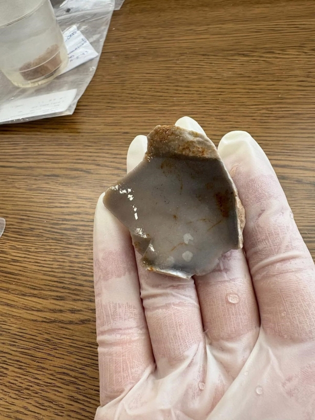 La investigadora Mayra Guajardo Sondón ha sido la primera en coger la lasca de sílex tras su hallazgo (UGR)