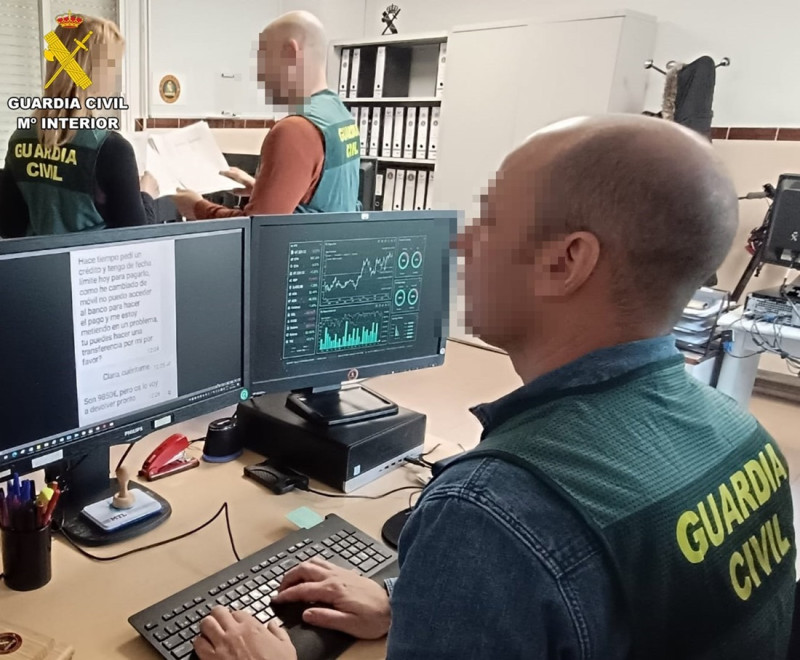 Agente de la Guardia Civil frente a un ordenador. Archivador. Agente de la Guardia Civil frente a un ordenador. Archivador.