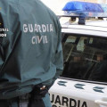 Un agente de la Guardia Civil junto a un coche patrulla (GUARDIA CIVIL)
